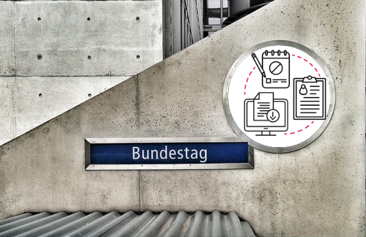 Auf einer grauen Betonwand ist ein Schild mit der Aufschrift "Bundestag". Rechts darüber ist ein weißer Kreis mit diversen Icons darin.